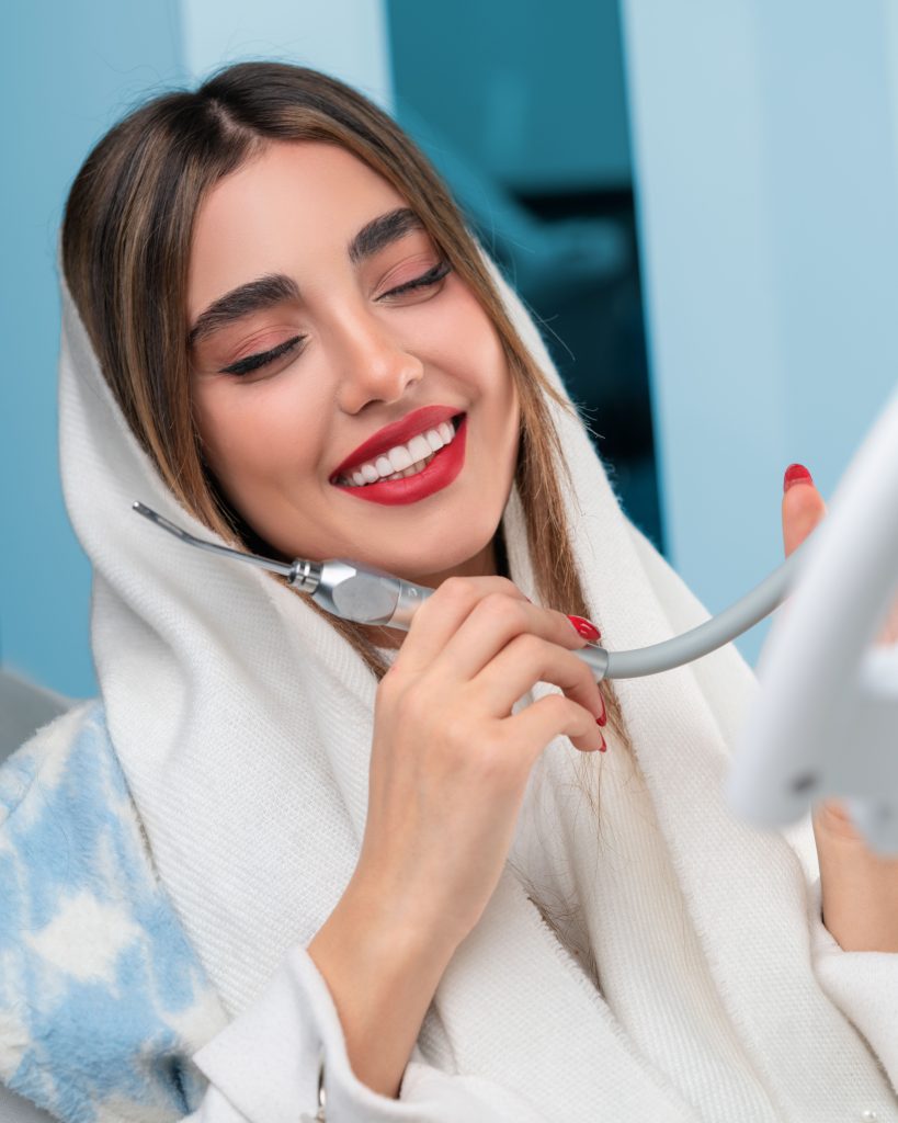 Woman holding a clear aligner at a dental clinic