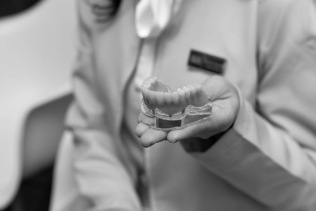 Dentist explaining a dental implant model